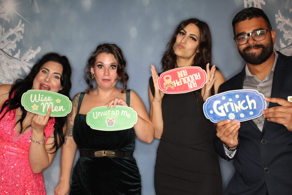 Friends posing with winter wonderland props at christmas party
